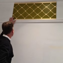 A gold-leafed design meticulously applied using a stencil.