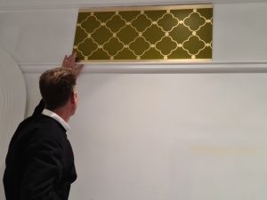 A gold-leafed design meticulously applied using a stencil.
