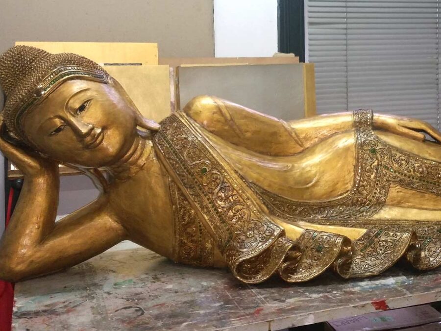 Restoration of a damaged Buddha statue with 23 carat gold leaf