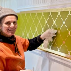 A gold-leafed design meticulously applied using a stencil.