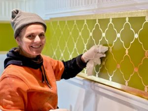 A gold-leafed design meticulously applied using a stencil.